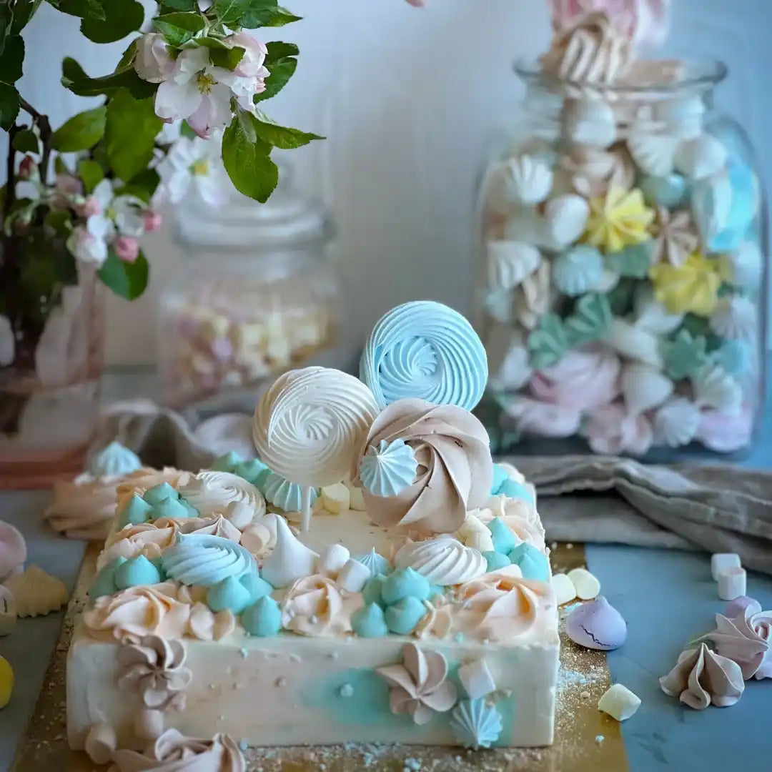 Ruutküpsetatud kook, mis on kaunistatud pastelshe pastelset värvi meringuurutidega ja võietopsikutega.