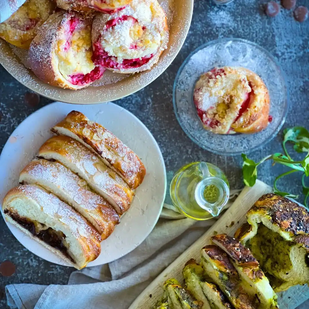 Valik magusaid ja soolaseid pagaritoodete, sealhulgas koorejuust ja puuviljaga täidetud kuklid, šokolaadibabka ja pestobrööt.